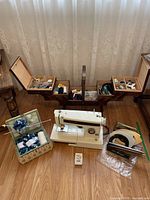 Full lot setup showing vintage Kenmore sewing machine in front with wooden foldable sewing box behind, and woven basket knitting supplies to left.