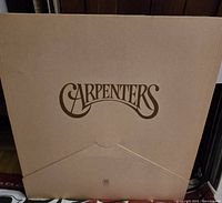 Photo of The Carpenters vinyl record album cover with beige background and large brown stylized text logo