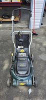 Front view of Yardworks cordless electric lawn mower showing handlebar, cutting deck, wheels and battery compartment.