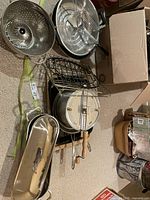 Overview of cookware and accessories including fish poacher, steamer, and metal racks.