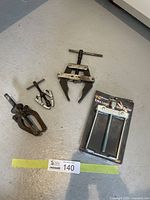 Four gear pullers of various sizes including a new extra large one in sealed packaging.