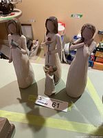 Front view of the four Willow Tree figurines showing carved wood-style finish and poses.