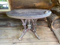 Front and side view of oval wood top table showing natural surface wear and patina on wood