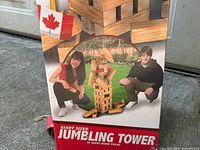 Photo of the game box featuring images of two young people with the built wooden block tower and Canadian flag. Shows overall packaging and branding.