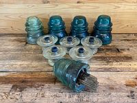 Full lot of 10 vintage glass insulators including aqua and green dome shapes and clear disc shapes, one with original wood mounting