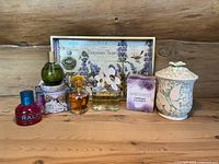 Full view of all perfume bottles and decor items arranged on wood surface with wooden background