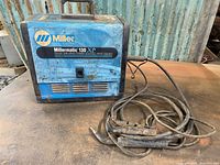 Front view showing Miller branding, power cable, and wire feed tube