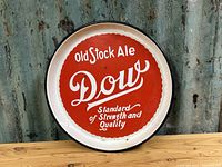 Front view of round metal beer tray with Dow Old Stock Ale red and white logo.