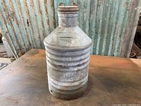 Full view of the ribbed galvanized metal tin can with embossed Imperial Oil branding and wide spout with cap.