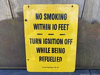 Photo of front side of yellow metal gas station safety sign showing the warning text 'No Smoking Within 10 Feet - Turn Ignition Off While Being Refuelled' and Ontario Regulation 276/66