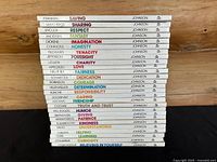 Stack of 27 hardcover ValueTales books showing spine titles with authorship by Johnson. Titles visible include Franklin – Saving, Lincoln – Respect, Helen Keller – Determination, and others.