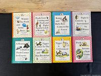 Full view of all 8 miniature Winnie-the-Pooh books arranged in two rows showing front covers with varied color backgrounds and character illustrations.