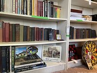Two shelves of antique books with various genres including history, poetry, and science; some books have visible wear and faded spines.