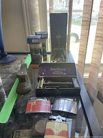 Full lot view showing Auto Strop razor box, shaving brushes in boxes, stapler, and three lighters.