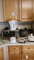 Countertop showing Breville convection toaster oven, Superior electric kettle, Kitchen Aid Architect slow cooker and other small appliances