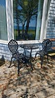 Full set of one table and two chairs on deck in front of house