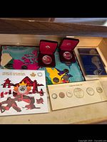 Overview of multiple Canadian commemorative coin sets in original packaging including colorful covers and display cases with coins inside.