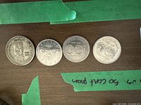 Four Canadian silver dollar coins displayed in a row showing the reverse sides with commemorative designs.