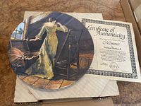 Collector plate titled 'Memories' with illustration of a woman and easel.