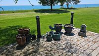 Wide view of all planters arranged on wooden deck outside, showing variety in size and material.