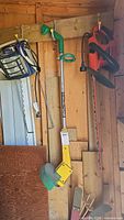 Photo shows Black and Decker hedge trimmer, weed eater, and worklight hanging on shed walls.