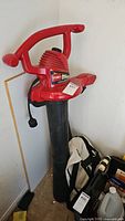 Full view of Toro red electric leaf blower/vacuum with collection bag.