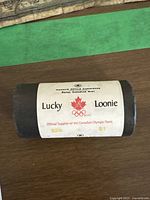 Rolled package of 2004 Canadian Olympic Loonie coins with label showing branding and text.