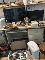 Desk setup with LG and ViewSonic monitors on top, keyboards and office items below desk.