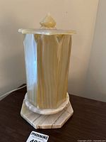 View of hexagonal onyx lamp body and base with natural stone veining.