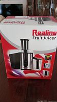 Box packaging front showing Realine Fruit Juicer name and image.