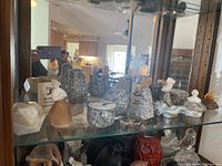 Photo showing all four Russian stone carving trinket boxes on a glass shelf with mirrored background.