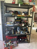 Full front view of the dark grey metal shelving unit loaded with various tools and storage containers, demonstrating shelf spacing and capacity.