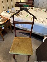 Full view of the wood valet chair showing the upholstered seat and wooden support structure.