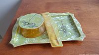 Full vanity set with tray, covered box, and comb on wooden surface