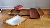 Photo of art glass decorative bowl, candy dish, and three serving trays on wood floor