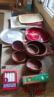 Photo showing wood salad bowls, two metal serving trays, candles, and folded fabric items