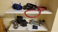 Shelf displaying the full lot including dumbbells, arm/ankle weights, hand grip strengthener and resistance band
