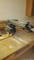 Craftsman 10 inch radial arm saw mounted on wooden bench, overview of arm and motor assembly.