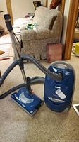 Full front view of the Kenmore Elegance canister vacuum with attached hose and power head on carpeted floor.