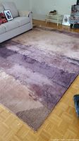 Calvin Klein wool area rug installed in a living space in muted purple and beige gradient colors