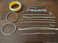 Group shot of all 11 bangles and chain bracelets laid out showing full assortment