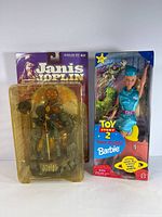 Front view of Janis Joplin figure and Toy Story 2 Barbie in original packaging