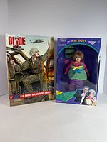 Front view of both boxed dolls displaying packaging and figure visibility
