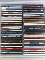 Overall view of four vertical stacks showing approximately 41 jewel-case CDs
