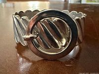 Front view showing circular clasp and ribbed sterling panels