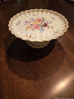 Top and angled view showing floral decoration, gold trim, and pedestal base of the comport.