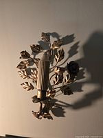 Metal Victorian style wall sconce with 24k gold leaf finish, leaf and rose floral design, ribbed candle holder, approx 8" x 12".