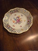 Image of a round hand painted porcelain sandwich or cake dish with pierced lattice edge and gold accents