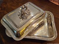 Silver plated entree dish partially disassembled showing removable lid and base with gadroon edges.