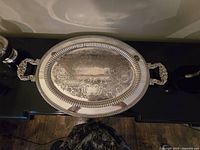 Top view of the oval silver plated tea tray showing the detailed engraved scrollwork and twisted rope inner border.